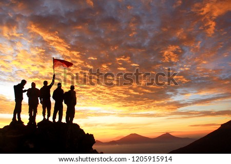 A group of young people watching the sun rise from the top of the Sindoro mountain in Central Java, Indonesia. In every climb always requires solidarity and determination to never give up