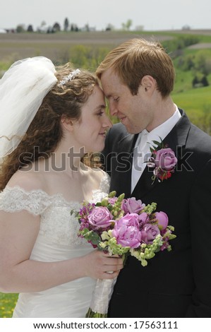 A young couple spends a quiet moment together in front of a Wisconsin farm field on their wedding day