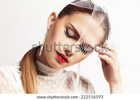 Beautiful woman with closed eyes wears white blouse and hat. Stylish accessories. Red lips. Hand near face.