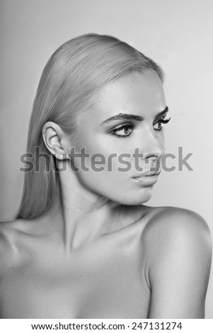Portrait of beautiful young woman with blonde hair. Professional make up. Studio portrait. Fashion model. Perfect beauty. Black and white