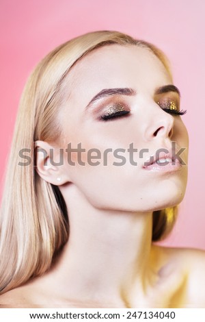 Portrait of beautiful young woman with blonde hair. Professional make up. Warm colors. Studio portrait. Fashion model. Perfect beauty Close eyes