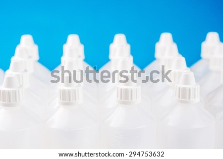 white translucent bottles on blue and blurred bottles background