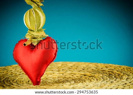 red heart decoration on background made of dry banana leaf with circle texture and turquoise color, vignetting