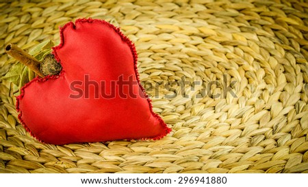 red heart decoration on background made of dry banana leaf with circle texture, vignetting