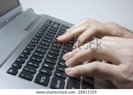 Notebook close-up photo, male hands typing on a laptop