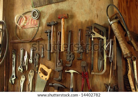 and tools hanging in an old shed. Vintage Hawaii State license plate in upper left