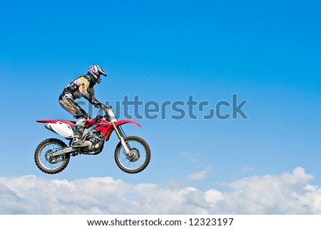 Motocross rider jumping above the clouds