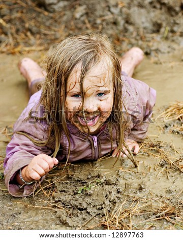 Happy Little Girl Playing in the Mud