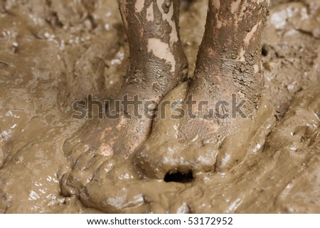closeup of a child\'s feet playing in the mud