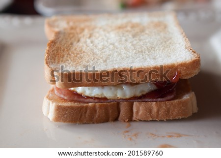 breakfast sandwich of toast , fried egg , ham