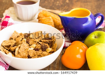 Bowl of delicious and healthy granola with dry fruits, nuts and milk.