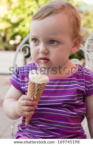 cute little girl eating ice-cream in a cafe
