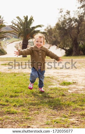 Cute little girl playing at park. Photo in an old colour