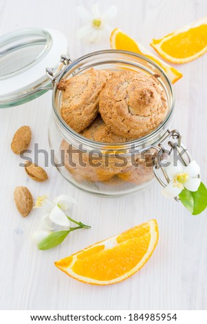 Fresh homemade nut cookies with orange and flowers on a wooden table