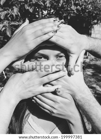 Female Model with several Hands on Her Face in black and white.
