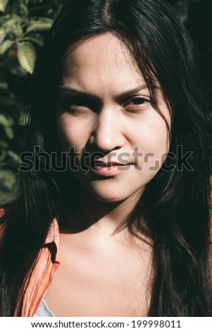 Head shot of Black Haired Woman looking at the camera.