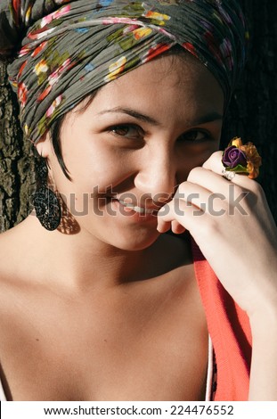 Pretty Smiling Young Woman with head Cover Hand on Face. Looking at Camera.