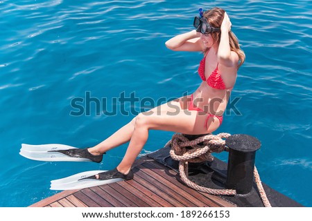 Caucasian girl with snorkeling mask and fins. Happy woman is smiling  in sunny summer day (Sharm El Sheikh, Egypt).