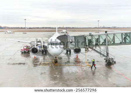 Warsaw, Poland - January 13, 2015: Airport passengers are go out of the plane at terminal gate. Disembarking of airplane. Modern international airport.