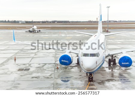Warsaw, Poland - January 13, 2015: Airplane (Enter Air) is near the terminal gate ready for takeoff (waiting for the flight). Modern international airport.