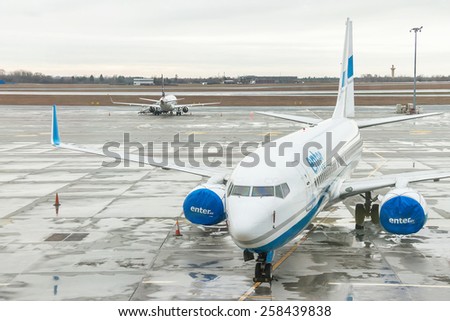Warsaw, Poland - January 13, 2015: Airplane (Enter Air) is near the terminal gate ready for takeoff (waiting for the flight). Modern international airport. World\'s travel, air transport concept.