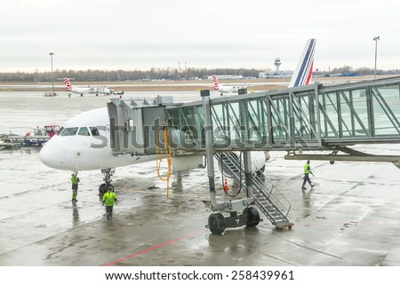 Paris, France - January 13, 2015: Airport workers (crew) are preparing for disembarking  passengers near terminal gate. Disembarking of airplane. World\' s travel, air transport concept.
