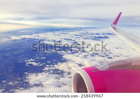 Airplane (aircraft ) is in the sky. Clouds over ground and line of horizon. World\'??s travel, trip, air transport concept. Day, outdoor.