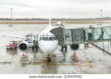 Warsaw, Poland - January 13, 2015: Airport passengers are go out of the plane at terminal gate. Disembarking of airplane. Modern international airport. World\'s travel, air transport concept.