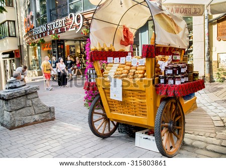 Zakopane, Poland - August 24, 2015: Oscypek chees and polish food sales on famous Krupowki street. Oscypek protected by EU law as regional product. Near is gateway to fashion street - Krupowki, 29.