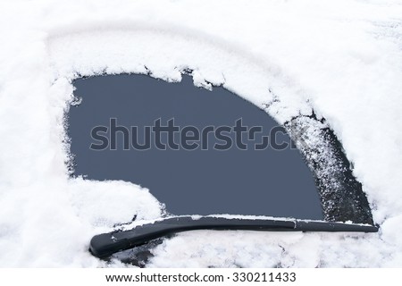 Transportation, winter, weather, vehicle concept. Car\'s window has been cleaned from snow by wipers in the winter day. Empty window for your message. Image has copy space for text. Close up.