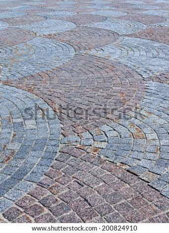 Cobbled pavement of red and gray cobblestone. Small depth of field.