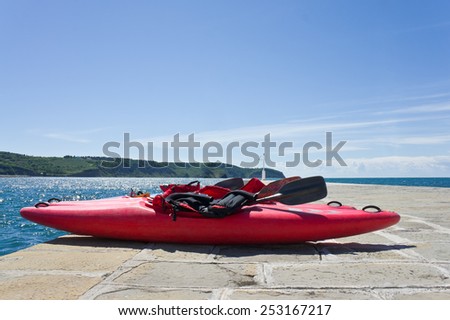 Boat with sports equipment is on the pier near the sea