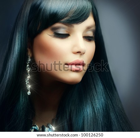Beautiful Brunette Girl. Healthy Long Hair and Holiday Makeup. Jewelry
