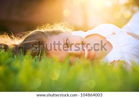 Beautiful Girl Lying On The Field.Green Grass. Happy And Smiling