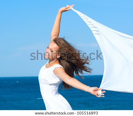 Freedom Concept.Beautiful Girl with White Scarf standing on the Rock. Flying.Free.Vacation