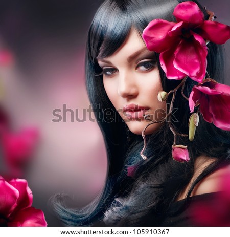 Fashion Brunette Girl with Magnolia Flower isolated on Black