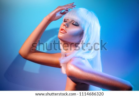 High Fashion model girl in colorful bright sparkles and neon lights posing in studio, portrait of beautiful woman, trendy glowing make-up. White hair, colorful make up. Glitter Vivid neon makeup