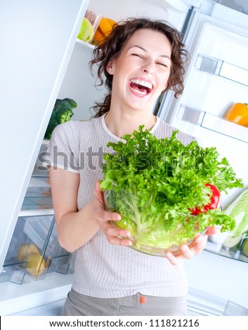 Fridge. Healthy Eating Concept .Diet. Beautiful Young Woman near the Refrigerator with healthy food. Fresh Fruits and Vegetables