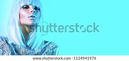 High Fashion model girl in colorful bright neon lights posing in studio, portrait of beautiful woman, trendy glowing metallic make-up. White hair, silver colorful make up.  Cosmic Vivid neon makeup