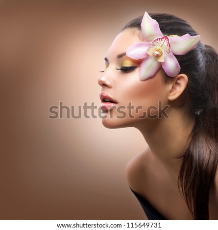 Beauty Portrait. Beautiful Stylish Girl with Orchid Flower. Pastel Colors. Perfect Face Skin