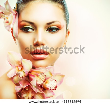 Beautiful Girl With Orchid Flowers.Beauty Woman Face.Vogue Styled Fashion Portrait. Professional Make-Up.Makeup