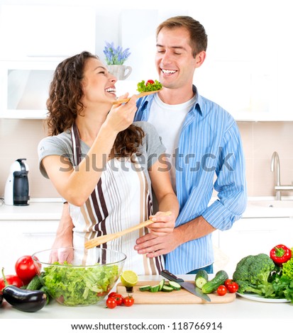 Cooking.Happy Couple Cooking Together - Man and Woman in their Kitchen at home Preparing Vegetable Salad.Diet.Dieting. Healthy Food