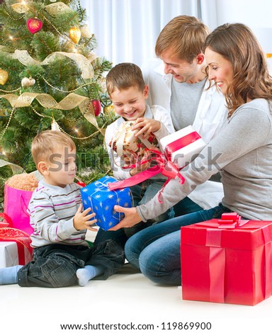 Christmas Family with Kids. Happy Children Opening Gift. Christmas tree