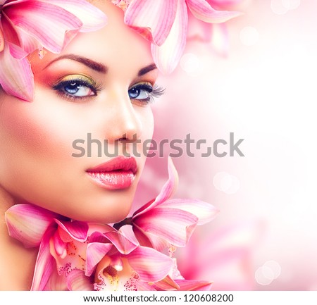 Beauty Girl With Orchid Flowers.Beautiful Model Woman Face. Perfect Skin. Professional Make-Up.Makeup. Fashion Art