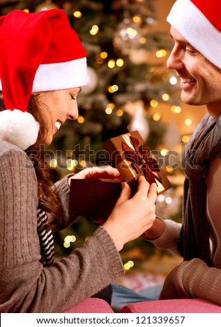 Christmas Gift. Happy Couple with Christmas and New Year Gift at Home. Smiling Family