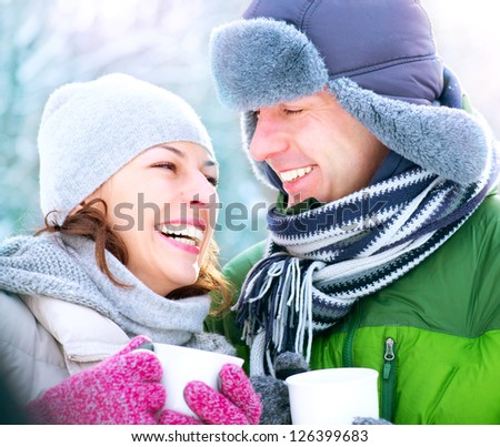 Happy Couple Having Fun Outdoors. Snow. Winter Vacation. Hot Drink Outdoor. White Teeth