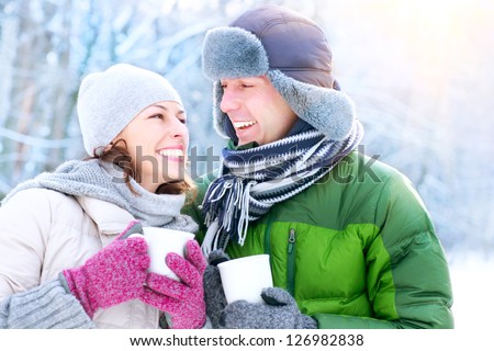 Happy Couple Having Fun Outdoors. Snow. Winter Vacation. Hot Drink Outdoor.
