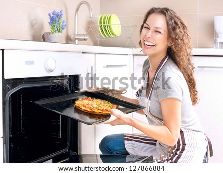 Happy Young Woman Cooking Pizza At Home. Oven