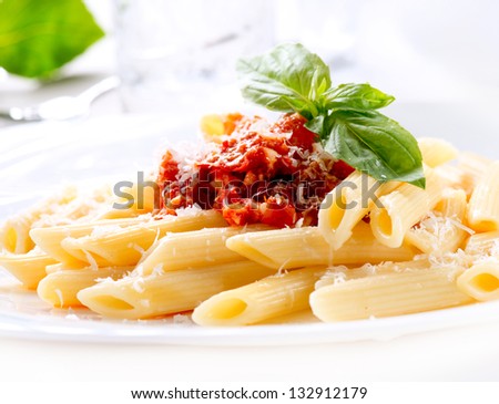 Pasta. Penne Pasta with Bolognese Sauce, Parmesan Cheese and Basil on served Table. Italian Cuisine. Mediterranean food