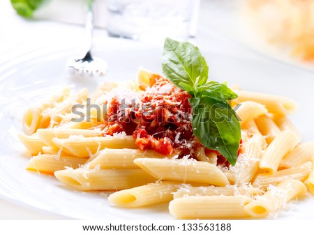 Pasta. Penne Pasta With Bolognese Sauce, Parmesan Cheese And Basil On A Fork. Italian Cuisine. Mediterranean Food